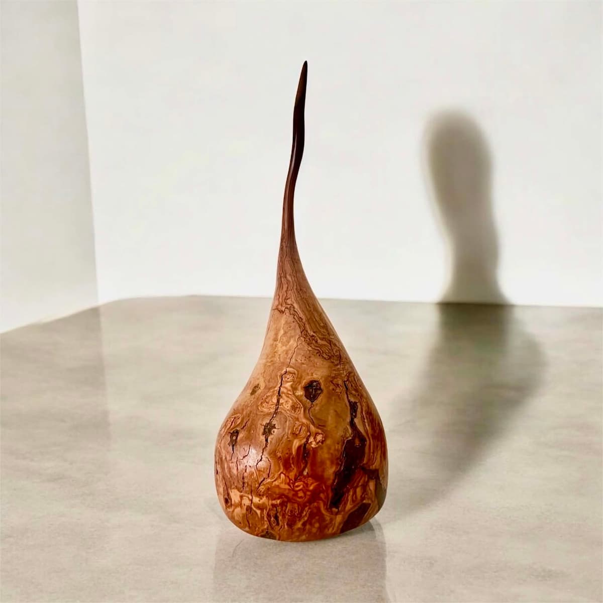 Teardrop timber sculpture photographed front-on in soft studio light